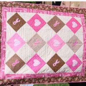 Quilt by Midge Kincaid Diamond shaped squares, pink, grey, brown in color.